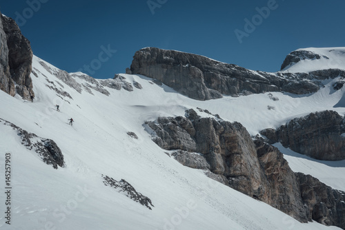 Ski mountaineers ascending towards the pass photo