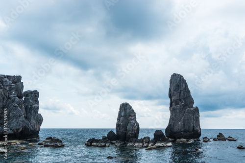 Beautiful rock mountain island on the sea with blue sky and clouds