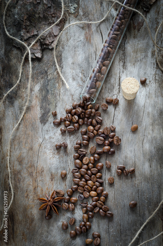 Bean coffee in a glass vial on aged wood photo
