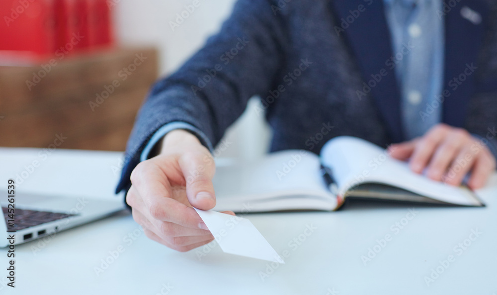 Man hand giving business card in office. Man showing blank business card. Person in blue suit. Mock up design. Man hand giving business card in office. Man showing blank business card. Person in blue suit. Mock up design.