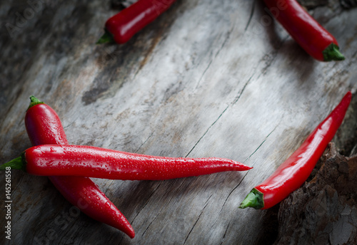 Red chillies on aged wood background