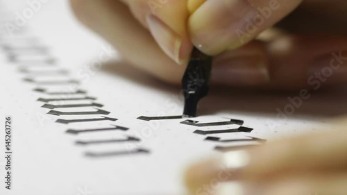 Woman writes pen with calligraphic letters photo