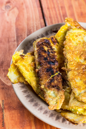 Flat lay fried zucchini in flour and eggs over wooden background