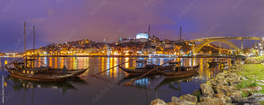 Panoramic view, traditional rabelo boats with barrels of Port wine on the Douro river, Ribeira and Dom Luis I or Luiz I iron bridge on the background, Porto, Portugal.