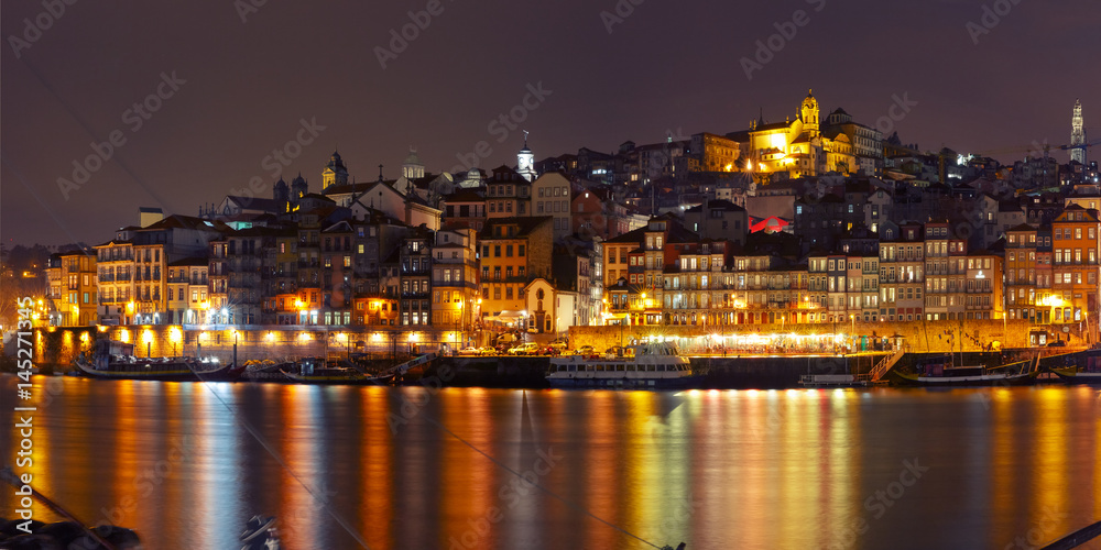 Ribeira and Old town of Porto with mirror reflections in the Douro River during evening blue hour, Portugal, Portugal.