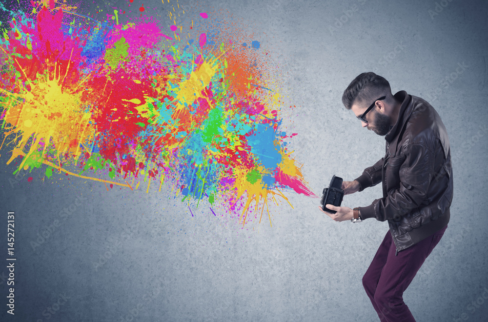 Hipster guy with camera and paint splash