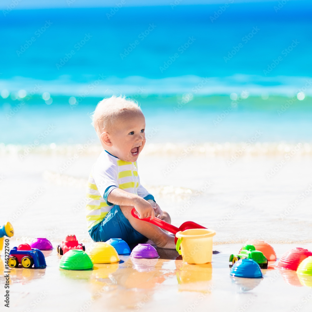 Baby playing on tropical beach digging in sand Baby playing on tropical beach digging in sand