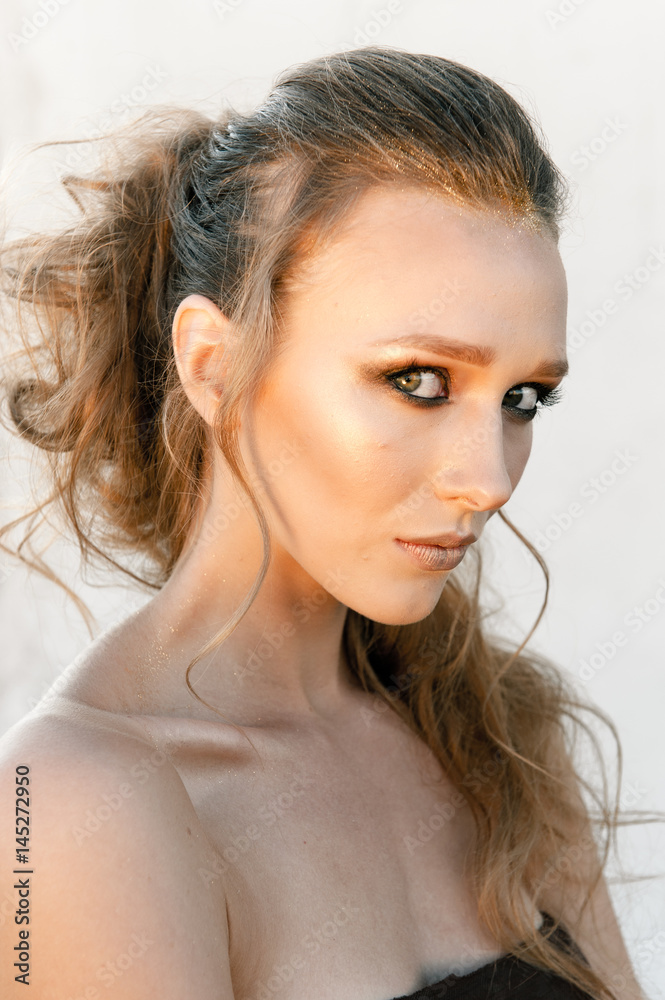 Glamour portrait of young fashion woman face with bright evening golden make up for party. Warm toning Glamour portrait of young fashion woman face with bright evening golden make up for party. Warm toning