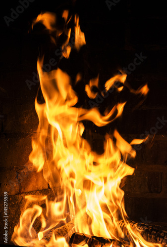 Near a flaming fire, covering all the wood