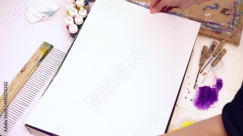 Woman artist transfering the ebru picture to the paper