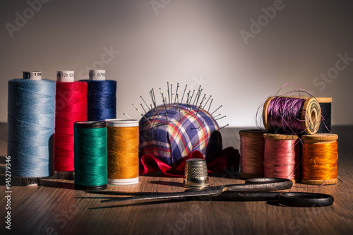 Still life of cotton spools in different colors with antique scissors.