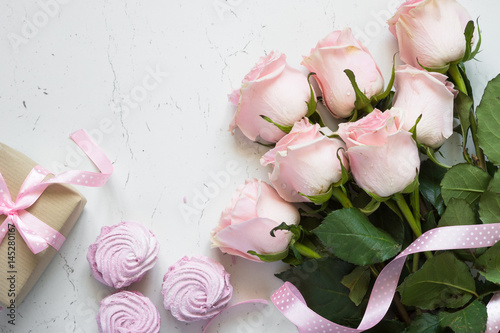 Pink rose dessert and present  at white stone table. Holiday background. photo