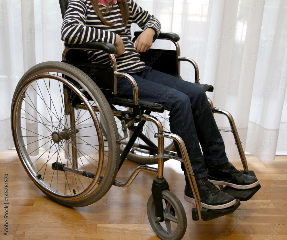 Obraz premium young disabled child in a wheelchair in her bedroom