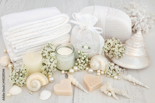 Bridal Spa Beauty Treatment Products and Accessories. With flowers, shells and pearls on distressed white wood background.