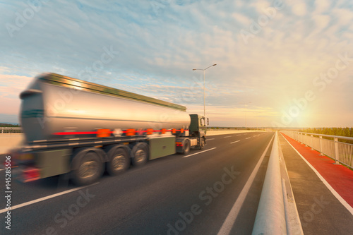 Tank truck on the empty highway at sunset