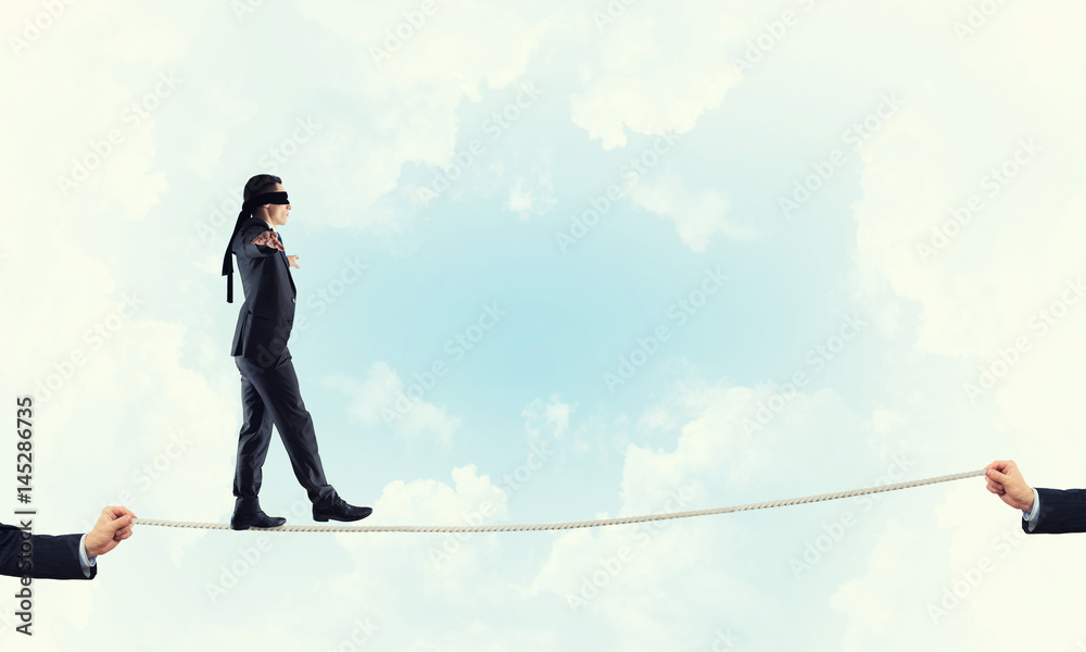 Obraz premium Business concept of risk support and assistance with man balancing on rope