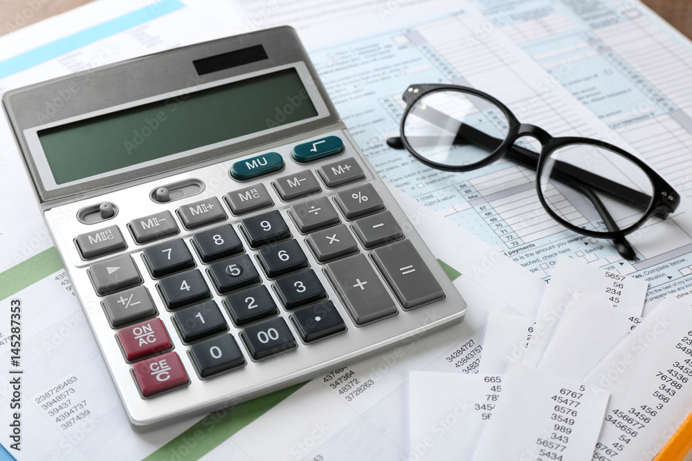 Calculator with documents and glasses on table. Tax concept Calculator with documents and glasses on table. Tax concept
