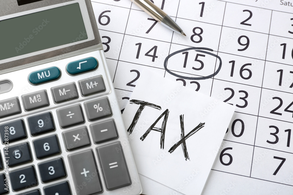 Calculator with pen on calendar. Tax concept Calculator with pen on calendar. Tax concept