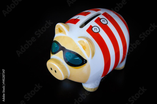 Piggy Bank with cool sunglasses on a black table