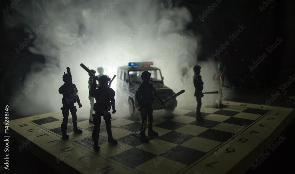 Anti-riot police give signal to be ready. Government power concept. Police on chessboard. Smoke on a dark background with lights. Blue red flashing sirens