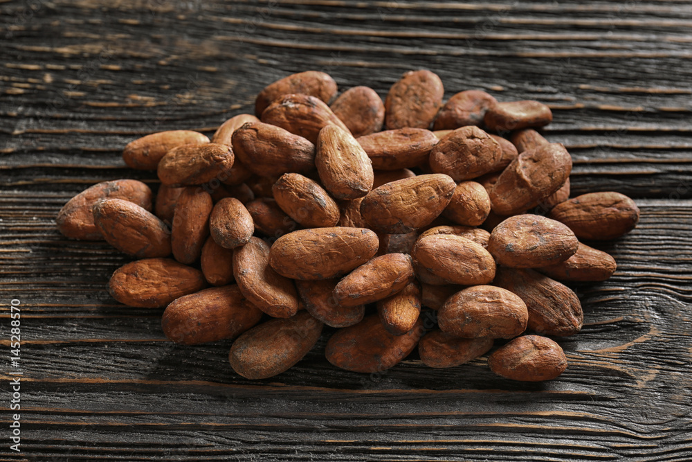Aromatic cocoa beans on wooden table Aromatic cocoa beans on wooden table