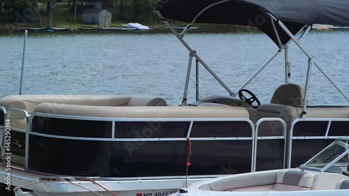 Anchored Boat Near Dock Bobbing on Lake During Cloudy Summer Day
