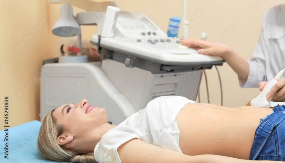 Young woman undergoing ultrasound scan in modern clinic Young woman undergoing ultrasound scan in modern clinic