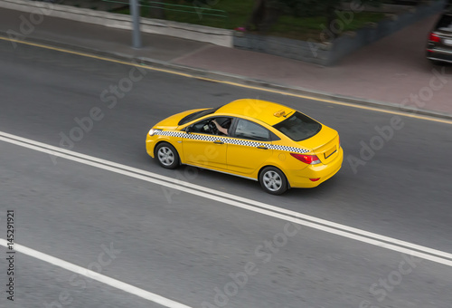 yellow taxi moves on the city