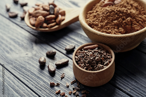 Composition with cocoa beans and powder on wooden background