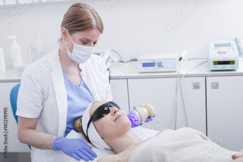 Face skin care. Woman getting facial laser treatment