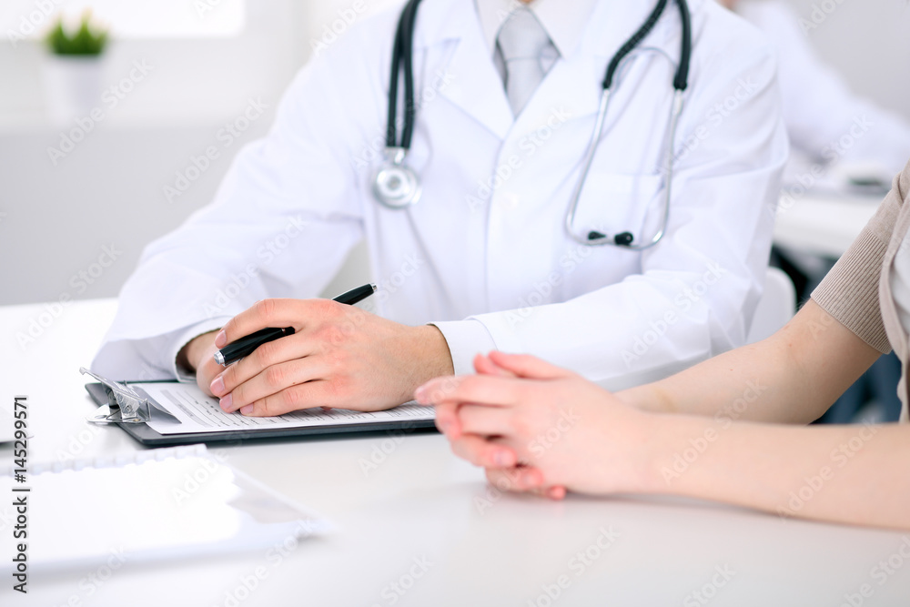 Doctor and patient are discussing something, just hands at the table Doctor and patient are discussing something, just hands at the table