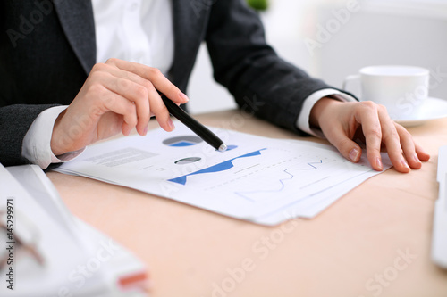 Business woman sitting at the table and examines the financial results