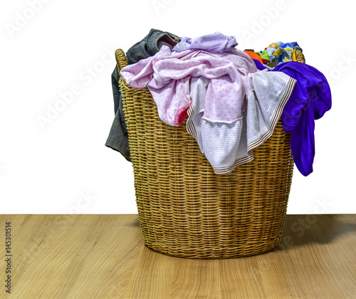 Lots of many clothes with in wicker basket on isolated background