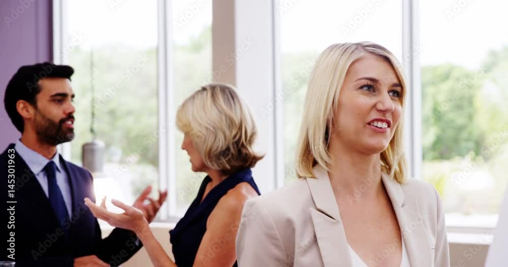 Business executives interacting with each other during break Business executives interacting with each other during break