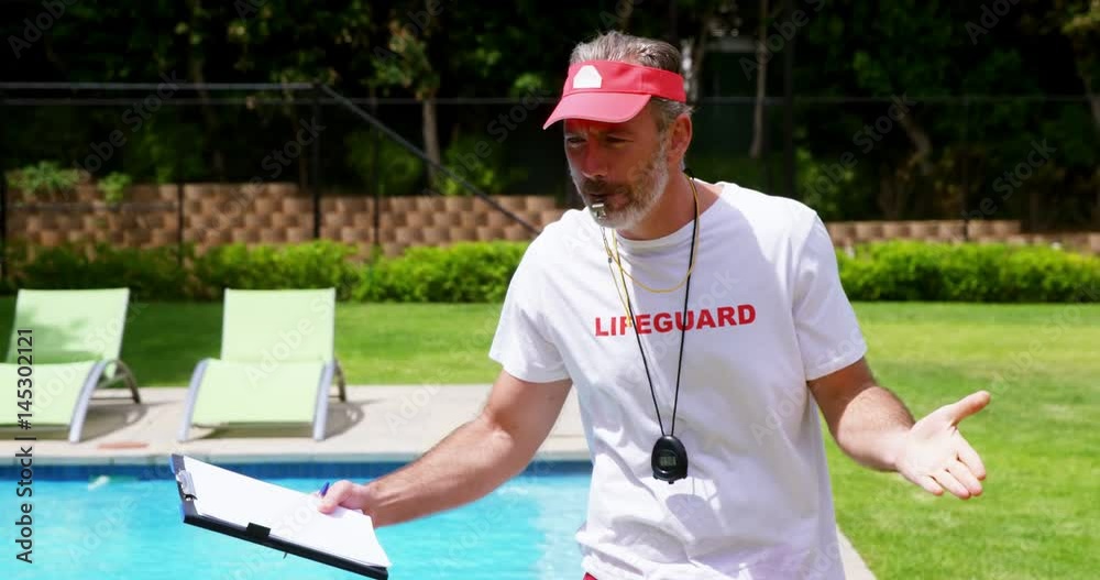 Lifeguard holding clipboard and whistling Lifeguard holding clipboard and whistling