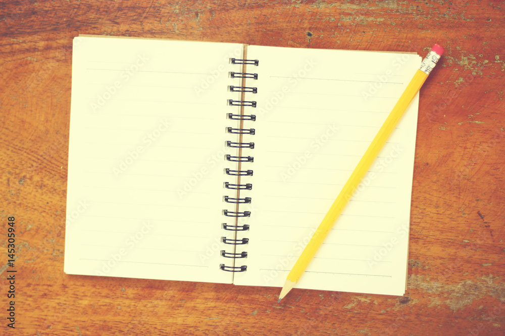 yellow pencil with notebook on wood table yellow pencil with notebook on wood table