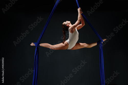 Sexy girl in white body on aerial silks