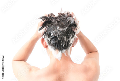 Closeup young man washing hair with white background, health care concept