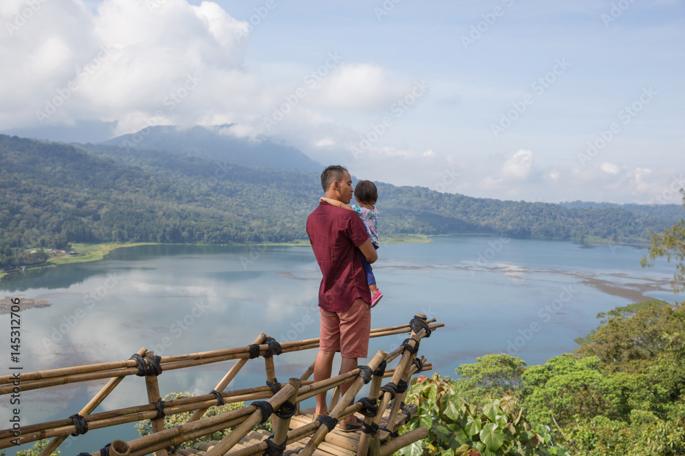 Fototapeta premium father and baby standing on cliff with beautiful view