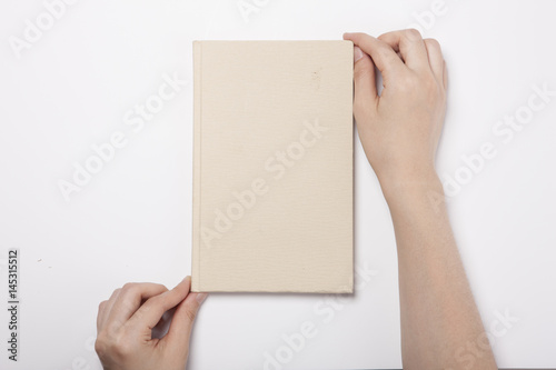 woman hand hold a book(note) with isolated white. © dohee