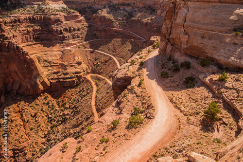 Tela A treacherous road with switchbacks descends into a desert canyon in Utah
