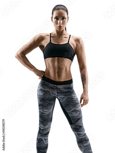Strong girl with beautiful muscular body posing on white background. Beauty and body care concept