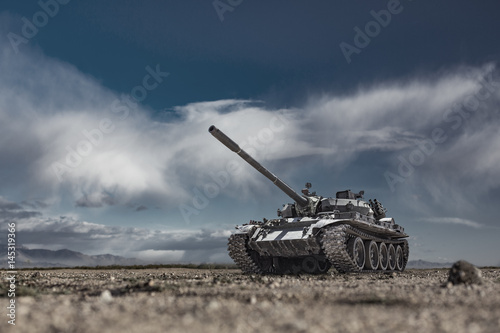 Military or army tank ready to attack moving over a deserted battle field terrain