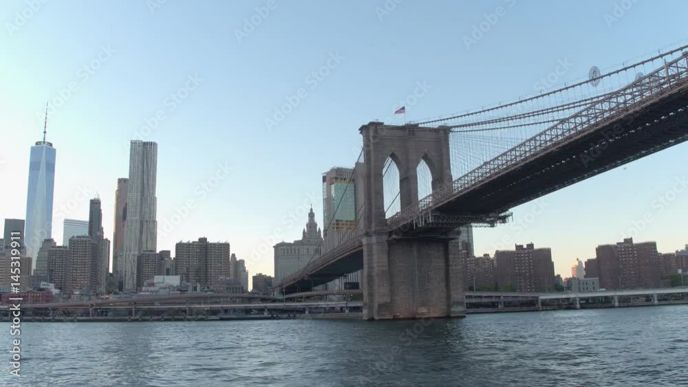 LOW ANGLE VIEW, CLOSE UP: Amazing sightseeing cruise on the East River along famous New York City skyscrapers toward iconic Brooklyn Bridge and residential tower blocks in Little Germany neighborhood LOW ANGLE VIEW, CLOSE UP: Amazing sightseeing cruise on the East River along famous New York City skyscrapers toward iconic Brooklyn Bridge and residential tower blocks in Little Germany neighborhood