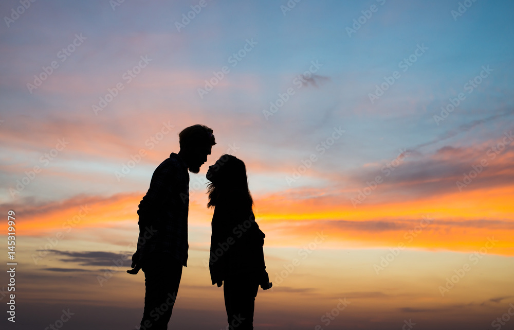 Silhouette young couple in love enjoy good time together during sunset.