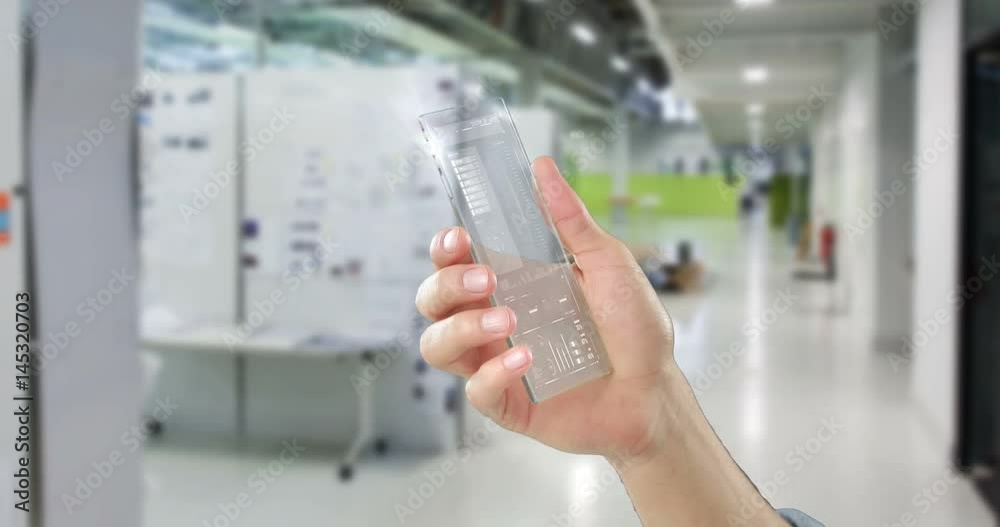Hand holding futuristic mobile phone in office Hand holding futuristic mobile phone in office