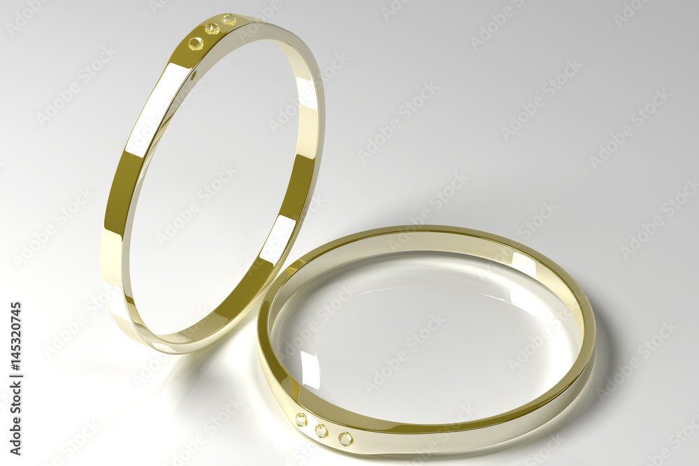Two golden rings with diamonds on a grey background Two golden rings with diamonds on a grey background