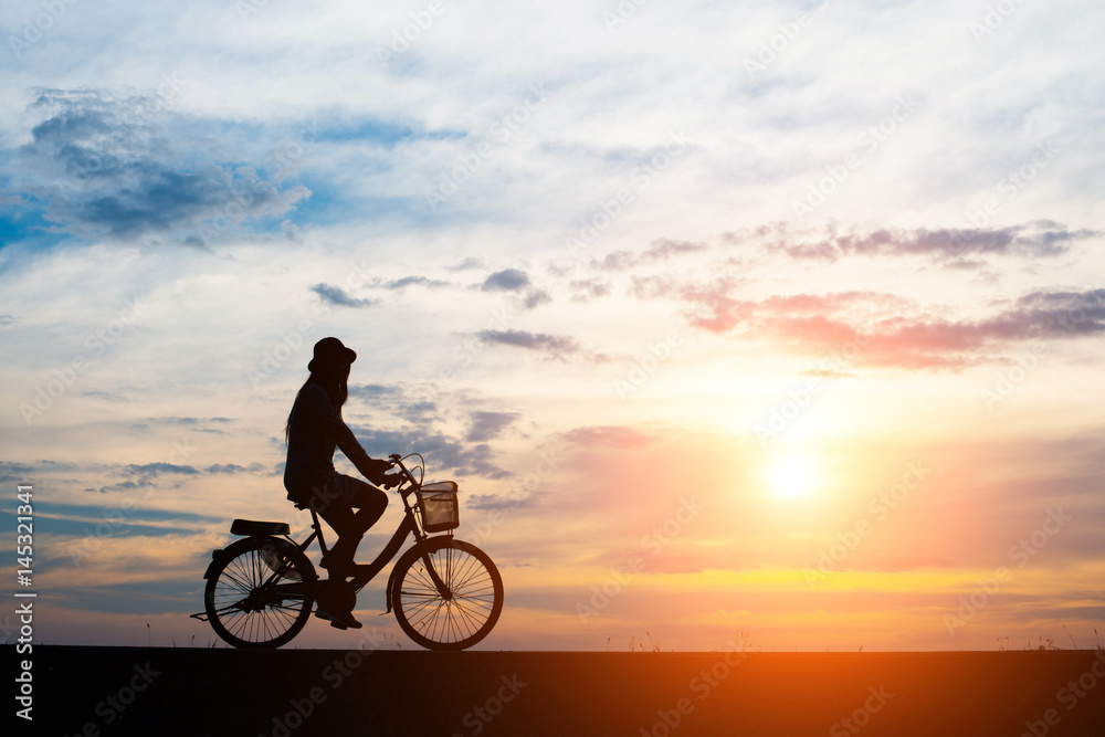 Fototapeta premium Młody człowiek jeździć na rowerze na tle zachodu słońca.