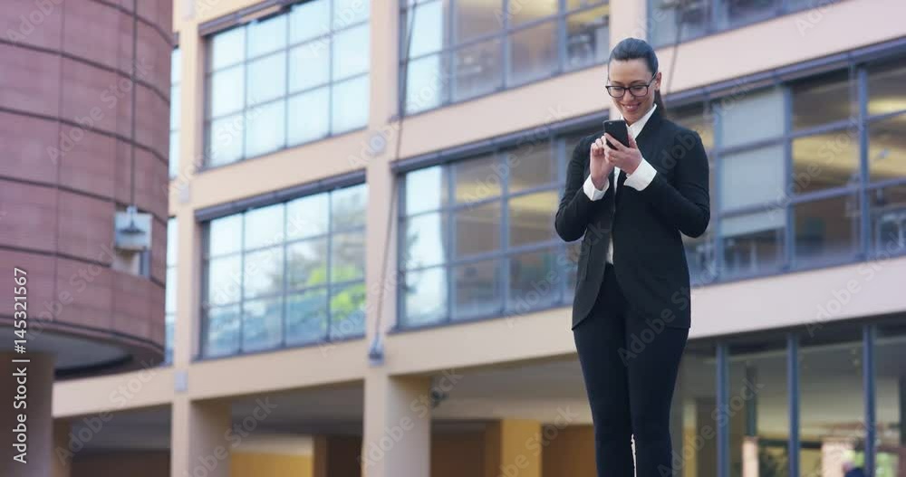 A business woman answering the phone, send messages and smiles for the beautiful job news and in the background business centre. Concept: technology, telephony, business trips, business, wall street