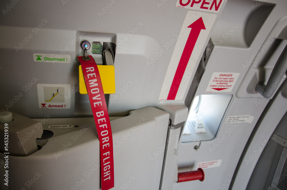 Fo your safety please remove before flight. Aviation & airplane detail - remove  before flight ribbon in a door. Stock Photo